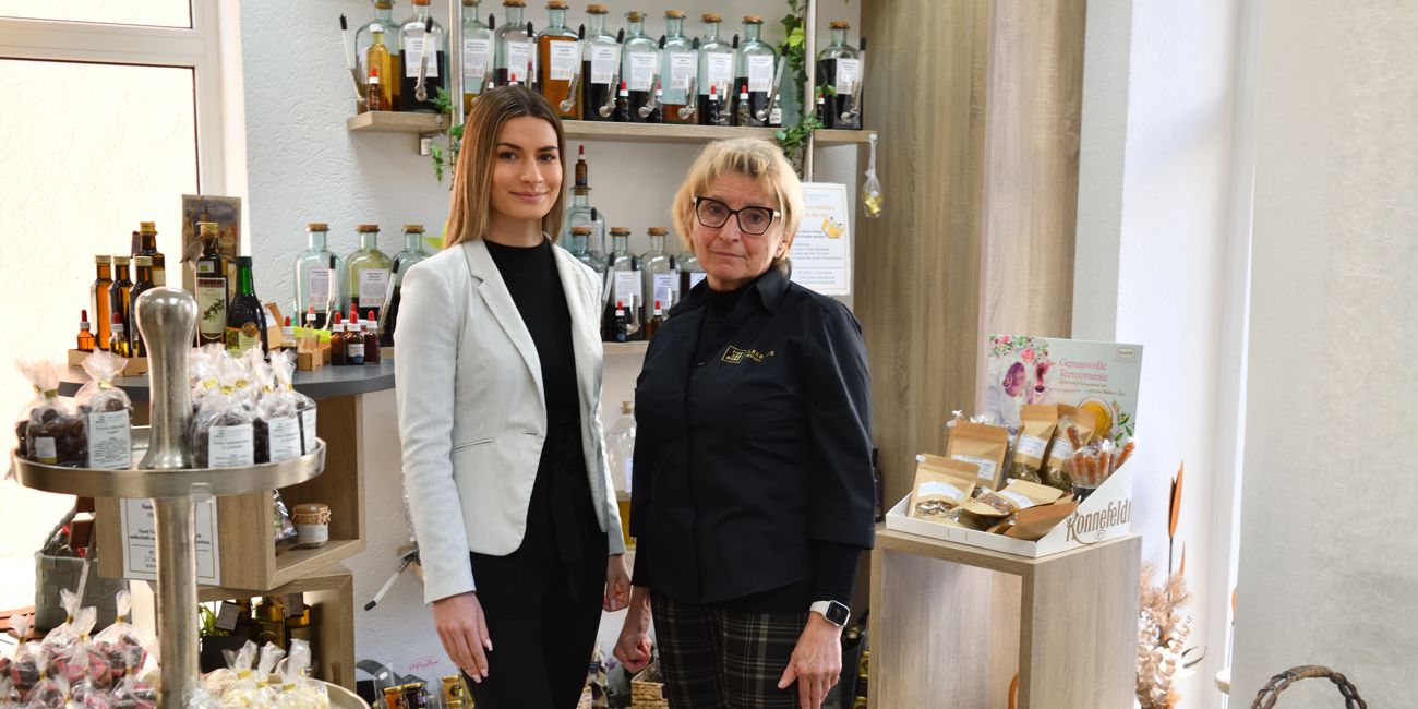 Sandra Hoffmann Referentin Private Banking und Margit Kleebauer vor der umfangreichen Ausstellung des Feinkostgeschäfts.