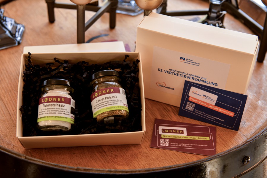 Offene Geschenkbox mit zwei Gewürzgläsern und einer Schachtel, daneben Infomaterialien in einer stilvollen Verpackung.