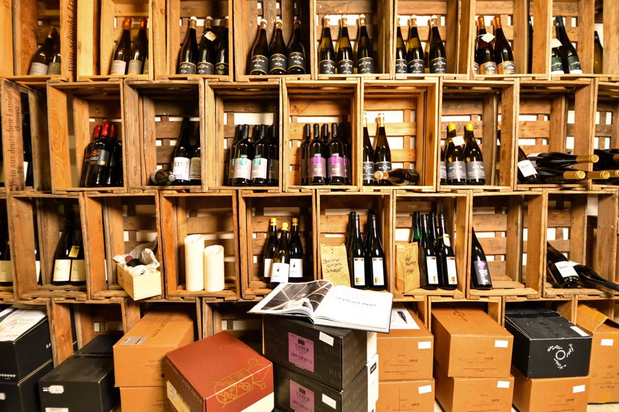 Ausstellung unterschiedlicher Weinflaschen in Kisten und Karton.