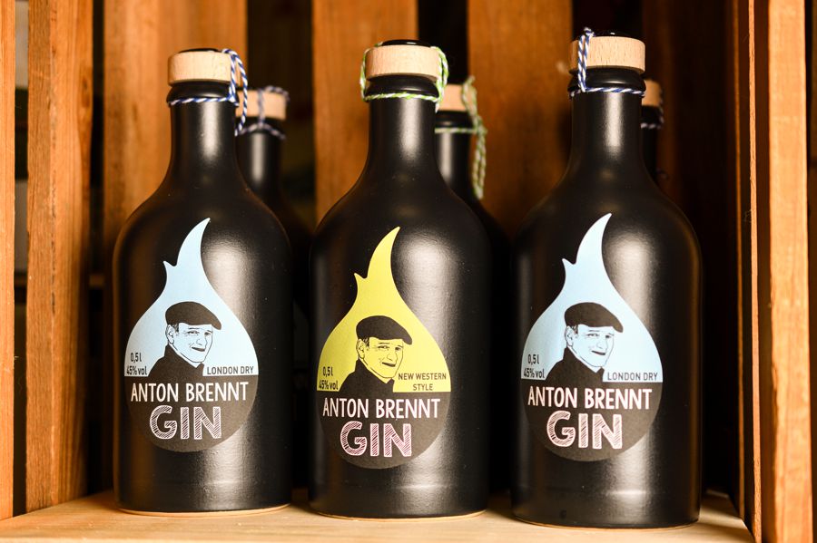 Ausstellung Gin-Flaschen mit Etikett Anton brennt Gin.