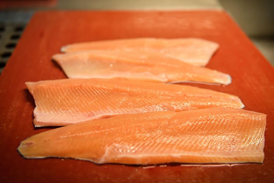 Fischfilets liegen fertig auf einem Brett.