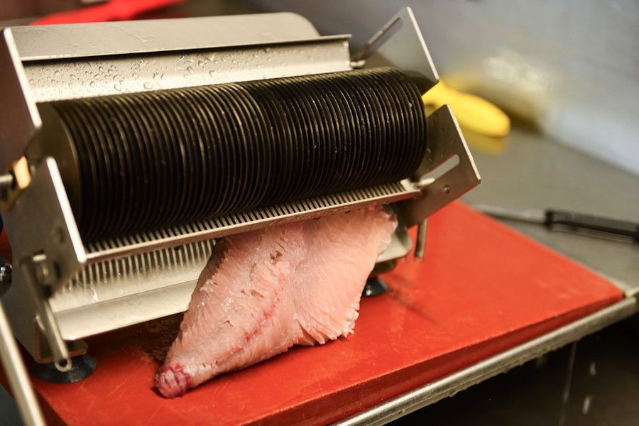 Weiterbearbeitung des Filets durch eine Maschine.
