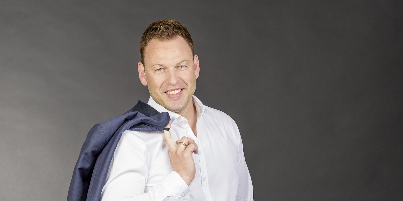 Christian Walter mit Anzugjacke über der Schulter.