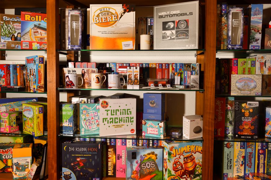 Auswahl an verschiedenen Spielen und Waren in Regalen. 