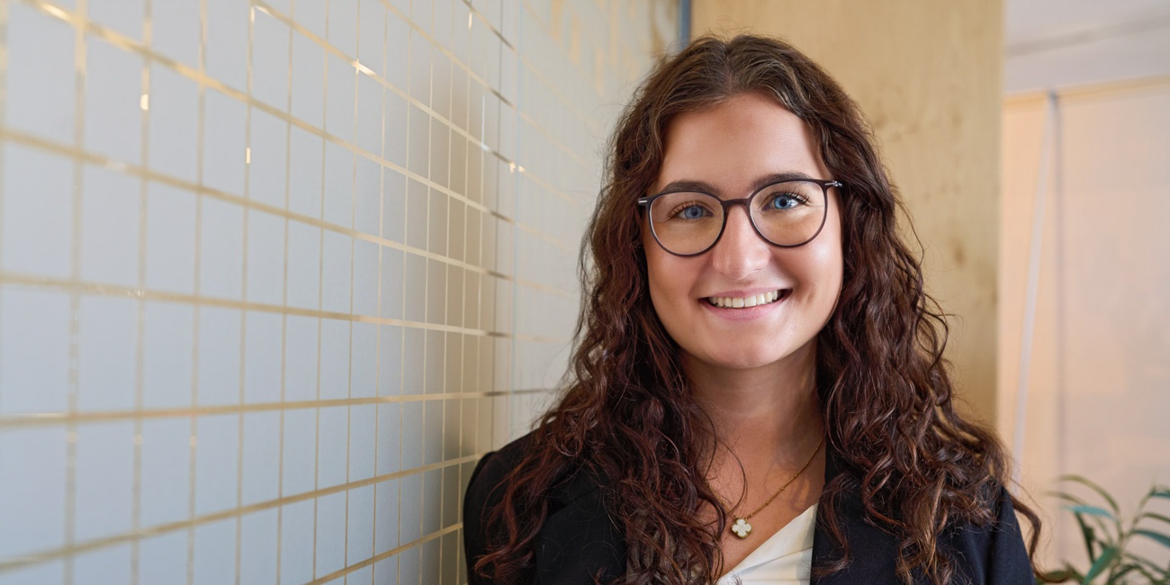 Eine junge Frau lächelt in die Kamera.