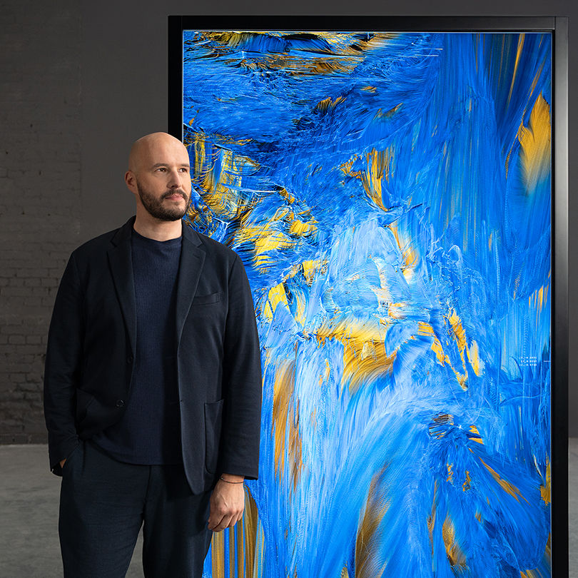 Andreas Lutz, Medienkünstler steht vor einem Gemälde.